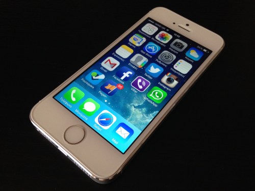 A smartphone displaying various app icons on its home screen, set against a dark background.