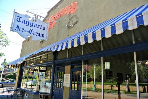 A storefront with a striped awning and a neon sign reading "Taggart's Ice Cream."