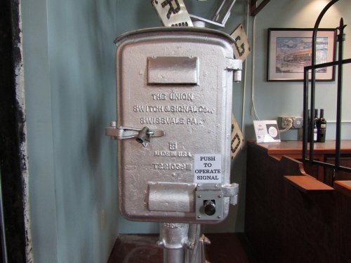 A vintage signal control box with a push button, labeled "The Union Switch & Signal Co., Swissvale, PA."