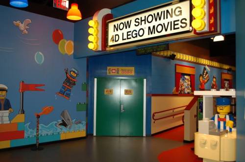 Colorful interior of a LEGO-themed theater, featuring a sign for 4D LEGO movies and playful wall decorations.