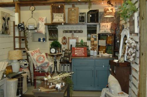 A cozy vintage shop display featuring rustic decor, furniture, and farm-themed items.