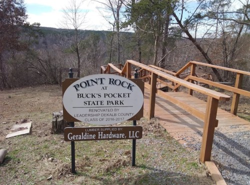Sign for Point Rock at Buck's Pocket State Park, with a wooden walkway and trees in the background.