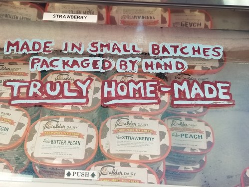 Handwritten sign above ice cream tubs reads: "Made in small batches, packaged by hand. Truly home-made."