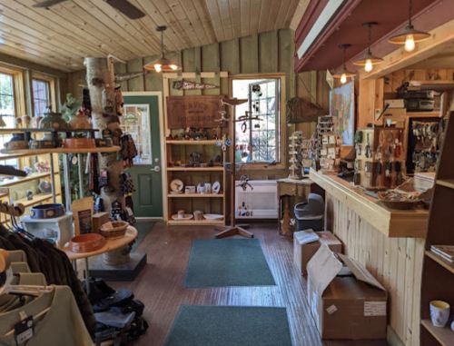 A cozy shop interior with wooden decor, shelves of merchandise, and a welcoming counter area.