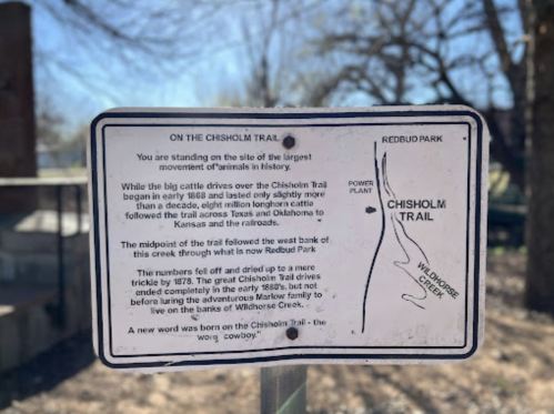 Sign about the Chisholm Trail, detailing its history and significance in cattle drives and animal movement.
