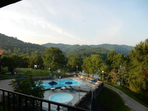 A scenic view of a pool area surrounded by trees and mountains under a clear sky.