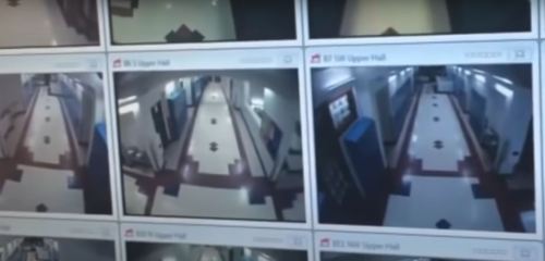Surveillance camera feed showing multiple views of a hallway with tiled floors and walls.