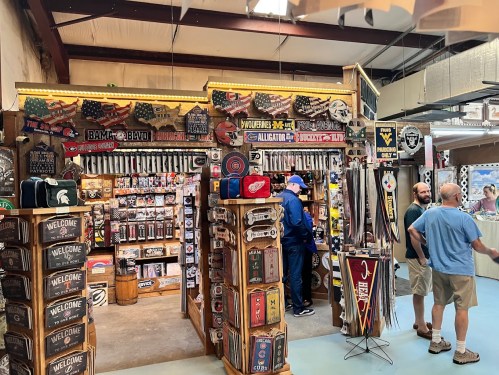 A vibrant store display filled with sports memorabilia and signs, with customers browsing and chatting inside.