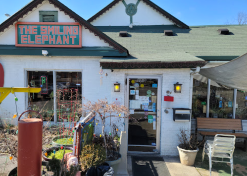 Exterior of "The Smiling Elephant" restaurant, featuring a colorful entrance and outdoor seating area.