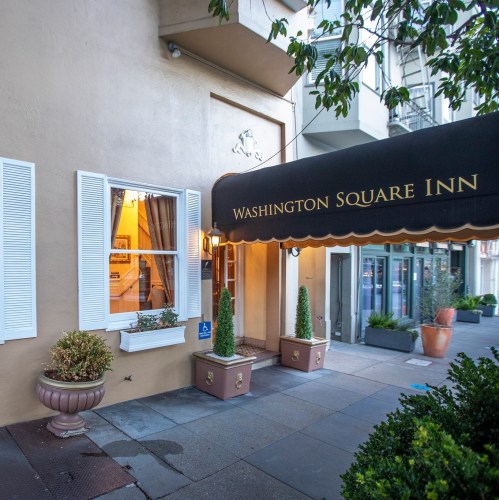 Exterior view of Washington Square Inn, featuring a welcoming entrance and potted plants.