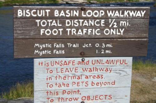 Sign for Biscuit Basin Loop Walkway, detailing distance, trail junctions, and safety warnings about pets and objects.