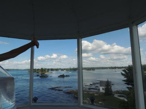 View from inside a lighthouse, showcasing a scenic river with islands and a cloudy sky.