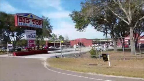 A view of the Big Top Flea Market with trees and a clear blue sky in the background.