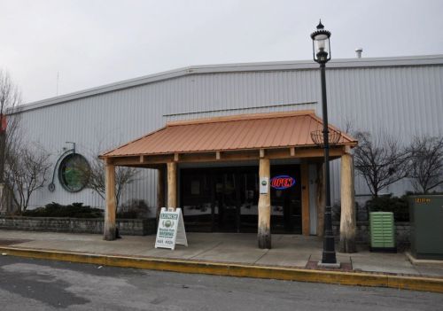 A building entrance with a copper roof, "OPEN" sign, and a sign for lunch specials outside.