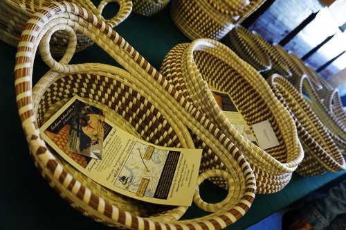 A collection of woven baskets displayed on a table, each with informational flyers inside.