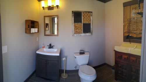 A modern bathroom featuring a sink, toilet, and decorative elements on the walls.