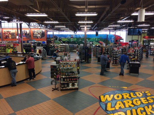 A spacious retail store interior with colorful displays, merchandise racks, and customers browsing.
