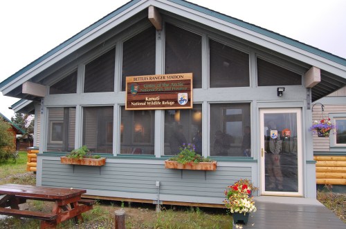 Exterior of Bettles Ranger Station with large windows, a sign for Kanuti National Wildlife Refuge, and flower planters.