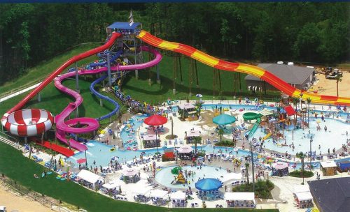 Aerial view of a vibrant water park featuring slides, pools, and numerous visitors enjoying the attractions.