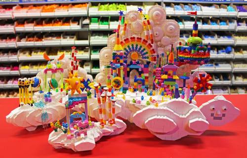 Colorful, whimsical structures made of various shapes and sizes, set against a backdrop of organized craft supplies.
