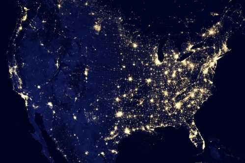 A nighttime satellite view of the United States, highlighting city lights across the eastern region.