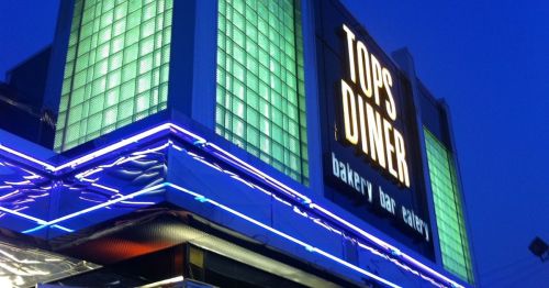 The neon sign for Tops Dinner at nighttime