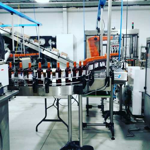 A production line with bottles on a conveyor belt in a factory setting.