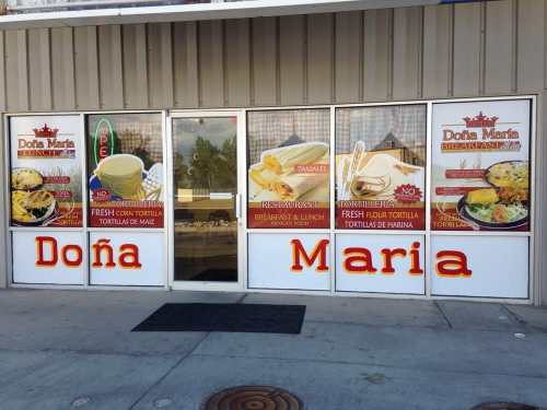 Exterior of a restaurant named "Doña Maria," featuring colorful signs for fresh tortillas and tamales.