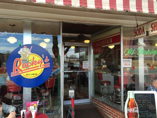 Exterior of Rocky's Soda Shop, featuring a colorful sign, retro decor, and a welcoming entrance with a menu board.