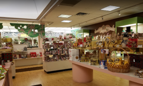 A brightly lit gift shop filled with colorful boxes, baskets, and holiday decorations on display.