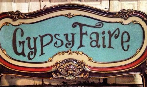 A decorative sign with the text "Gypsy Faire" in an artistic font on a turquoise background.