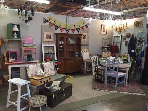 A cozy vintage shop filled with eclectic furniture, decor, and accessories, featuring a mix of colors and styles.
