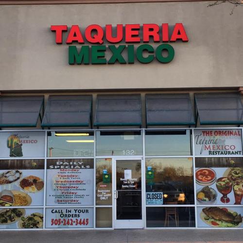 Exterior of Taqueria Mexico restaurant, featuring a colorful sign and large windows displaying menu items. Closed sign visible.