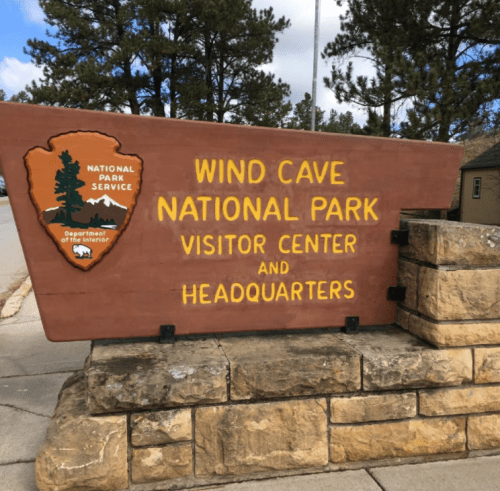 Sign for Wind Cave National Park Visitor Center and Headquarters, featuring the National Park Service logo.