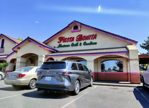 Exterior of Fiesta Bonita Mexican Grill & Cantina, featuring a colorful sign and parked cars in the lot.