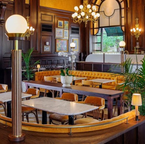 Elegant restaurant interior featuring plush seating, decorative lighting, and a warm color palette.