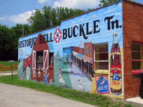 Colorful mural depicting scenes of historic Bell Buckle, TN, with buildings, people, and vintage advertisements.