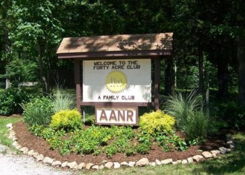 Sign for the Forty Acre Club, featuring "Welcome to the Forty Acre Club" and "A Family Club" with surrounding greenery.