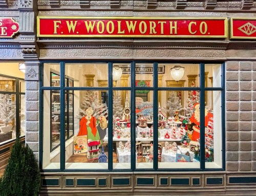 A festive display in a vintage F.W. Woolworth Co. storefront, featuring holiday decorations and cheerful scenes.