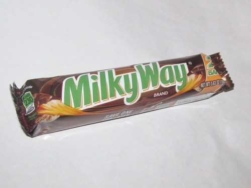 A Milky Way candy bar wrapper on a white background, featuring the brand name and nutritional information.