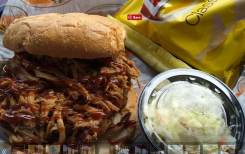 A pulled pork sandwich with barbecue sauce, a side of coleslaw, and a bag of chips on a tray.