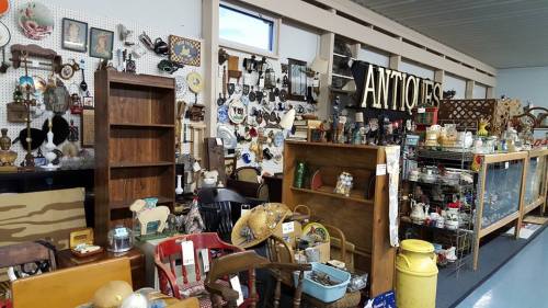 A vintage shop filled with various antiques, including furniture, collectibles, and decorative items on display.