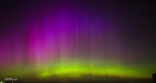 A vibrant display of the aurora borealis with purple and green hues against a starry night sky.