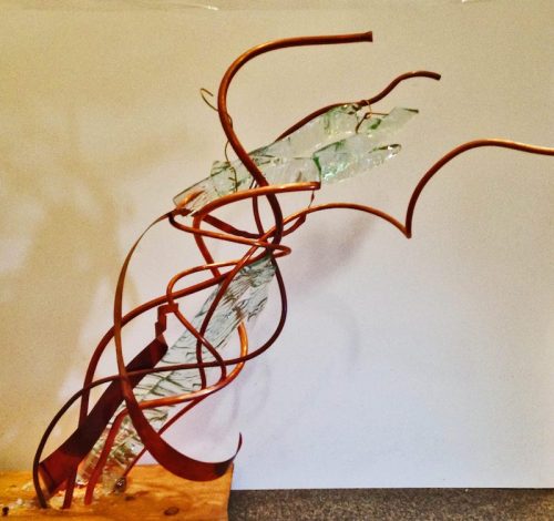 Abstract sculpture featuring twisted metal and glass elements, creating a dynamic, flowing form against a neutral background.