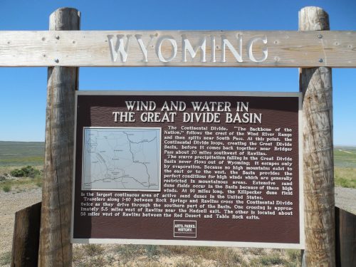 Sign about the Great Divide Basin in Wyoming, detailing its geography and significance in water flow and travel routes.