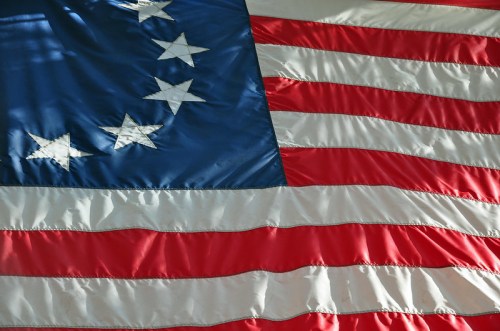 Close-up of a vintage American flag featuring red and white stripes with a blue field and white stars.