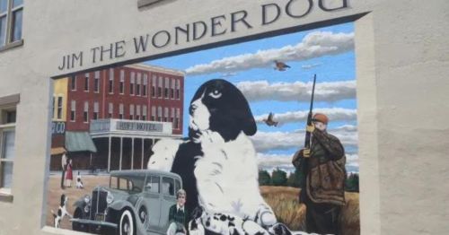 Mural of Jim the Wonder Dog, featuring a large dog, a vintage car, and a hunter in a rural setting.