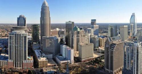 Aerial view of a modern city skyline featuring tall skyscrapers and clear blue skies.