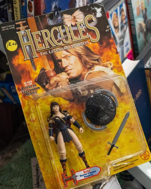 Action figure of Xena from "Hercules: The Legendary Journeys," featuring a sword and shield, in original packaging.