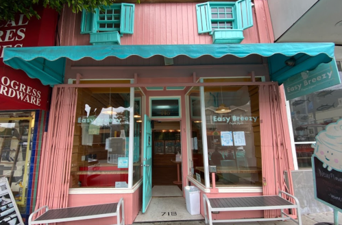 A pastel-colored storefront with teal shutters and a pink facade, featuring the name "Easy Breezy" on the door.